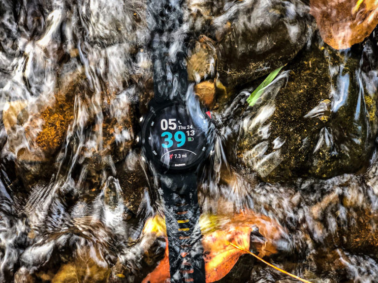 Waterproof Garmin Forerunner 245 GPS Watch Buyers Guide Garmin 245 on bottom mountain stream demonstrating its waterproof capabilities.